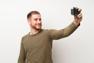 Handsome man over isolated white wall making a selfie