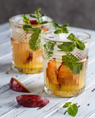 Two plum cocktails with mint leaves