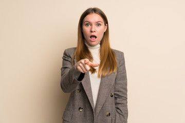 Young business woman surprised and pointing front