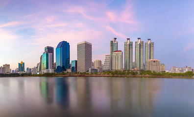 Fototapeta na wymiar Panorama of the beautiful bityscape of office building in the evening with water reflection at Benjakitti park ,Bangkok Thailand.