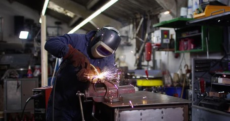 4K Unrecognisable mechanic welding auto parts with sparks flying