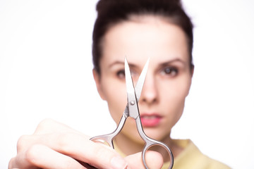 beautiful young girl holding scissors in her hands