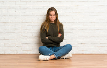 Young woman sitting on the floor feeling upset