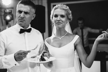 A confused groom is looking away. A bride is standing next to him. Black and white image.