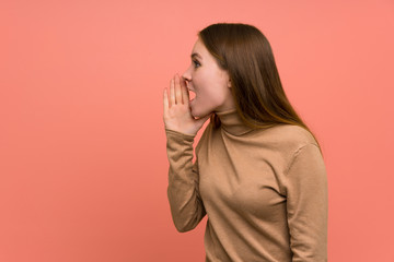 Young woman over colorful background shouting with mouth wide open