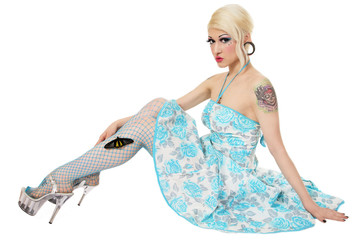 Young slim blonde gothic girl in vintage dress, fishnet stockings and stilettos over white...