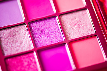 Set of pink glitter eye shadows in palette closeup. Decorative cosmetics.