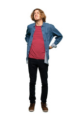 Fototapeta premium Full-length shot of Blonde man suffering from backache for having made an effort over isolated white background