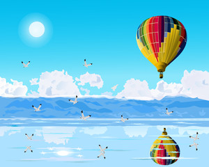 Colorful balloons are floating over the blue sea.Seagulls are flying  with reflections of balloons and birds.Mountains and sky as the background