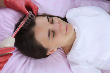 Obraz na płótnie Canvas Young woman at darsonval massage procedure in beauty salon