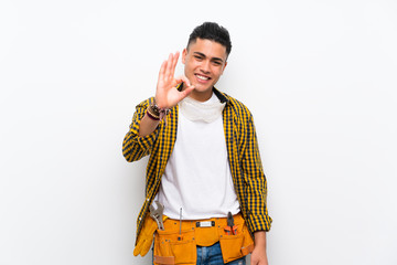 Young electrician man over isolated white wall showing ok sign with fingers