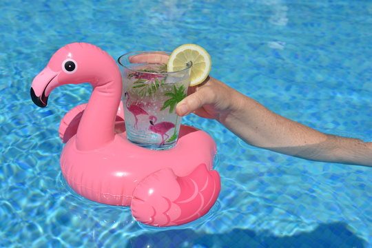 Hand Holding A Drink In A Pink Flamingo Inflatable Drinks Holder