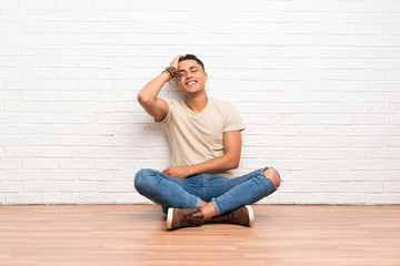 Young man sitting on the floor laughing