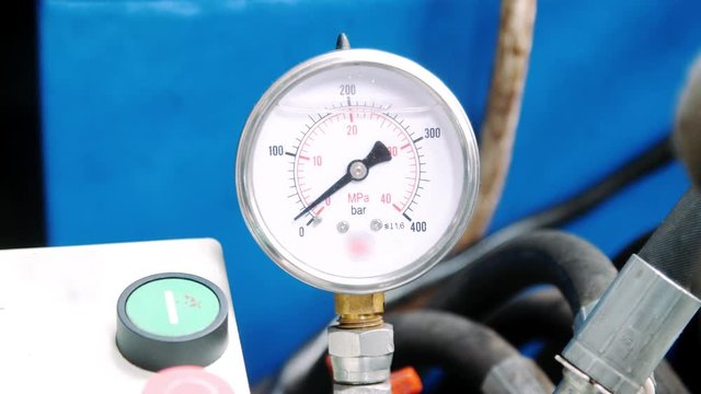 Manometer with arrow on industrial equipment. Pressure meters in workshop
