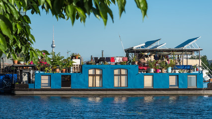 Fototapeta na wymiar Blue houseboat rests in Treptow in the river Spree. Berlin. Germany