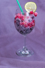 Glass with a cooling drink of berries and ice. Misted glass. Air bubbles on glass of glass.