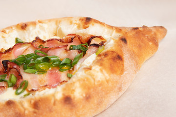 Traditional Georgian dish Khachapuri on a light wooden background close-up