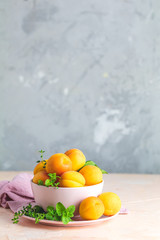 Fresh sweet orange apricots in pink bowl