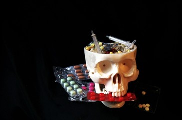 Skull and many medicine drugs, plato of pills, tablets, dangerous pharmaceutical concept.