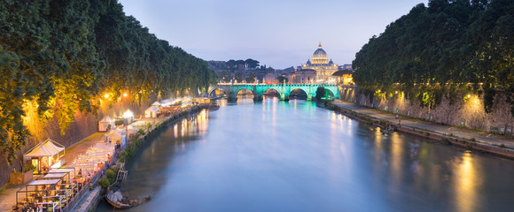 wide angle panorama of Tiber river with view to Cathedral of Saint's Peter in Rome in twilight time