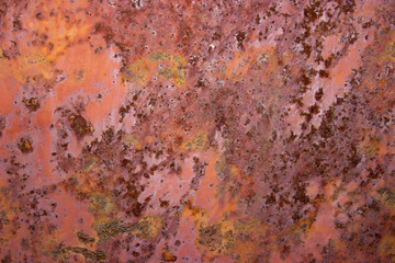 Brown background of rusty metal sheet with delaminations. Abstraction.