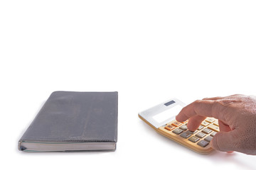 Hand using old calculator and old notebook beside on white background .