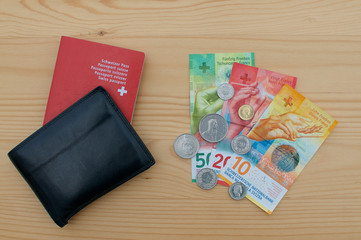 Obraz premium Black wallet with Swiss passport and swiss currency