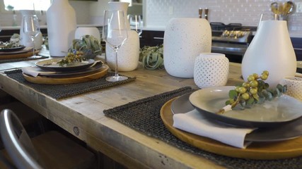 Dining Room Table Detail Move Right on Setting. view moves right on a close up of a place setting at a dining room table with kitchen in background