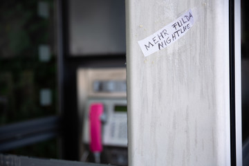 antikes silbernes Telefon mit roter Röhre und einer Telekom-Telefonzelle an der Wand aus dem...