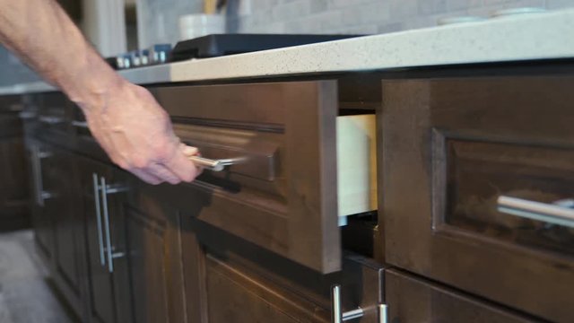 Kitchen Drawer Soft Close Feature Detail Move In Right. view moves along row of kitchen drawers as someone opens and places in a utensil then soft closes the drawer