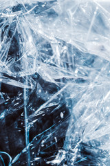 Texture of crumpled transparent cellophane. Concept of material for packaging, product protection against damage. Plastic free, save planet theme. Abstract neon light background. Clear glossy material