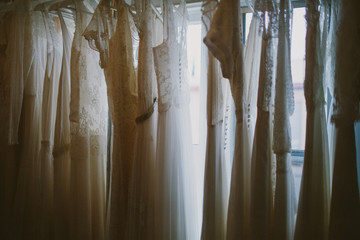 wedding dresses hanging in a window