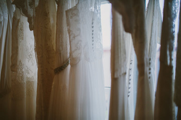 wedding dresses hanging in a window