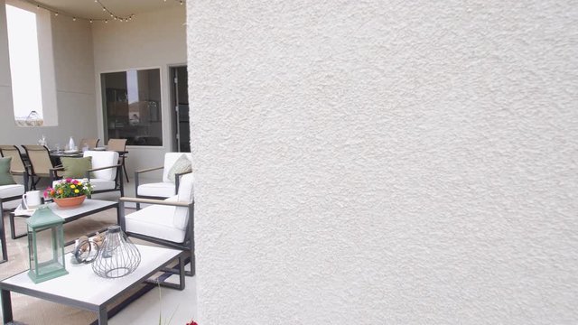 Backyard Patio Reveal from Home Wall. view moves left from a home exterior wall to reveal a backyard patio setting