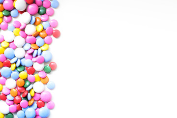 Chocolate dragee in a multi-colored glaze on a white background. Copy space