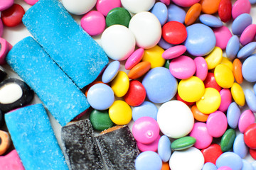 Licorice candy and chocolate dragee in a multi-colored glaze. Texture, background.