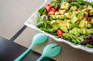 Natural vegetable salad, rich in vitamins and fiber, of green leaves and tomato and avocado in...