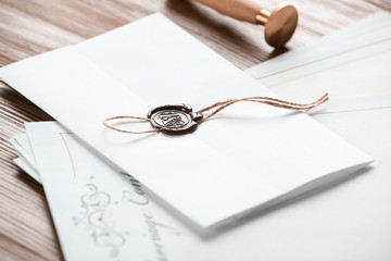 Document with notary seal and papers on wooden table, closeup