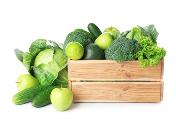 Wooden crate, fresh green fruits and vegetables on white background