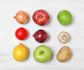 Flat lay composition with ripe fruits and vegetables on white wooden table