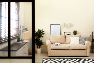 Fototapeta premium Living room interior with sofa, window blinds and stylish decor elements