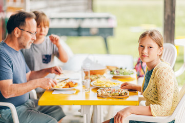 Family having lunch outside on a terrace, background with meal