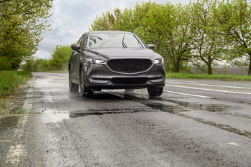 Wet suburban road with car on rainy day
