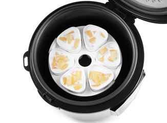 Cups of pineapple yogurt in multi cooker isolated on white, top view