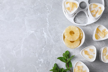 Flat lay composition with pineapple yogurt and ingredients on table, space for text. Multi cooker recipe