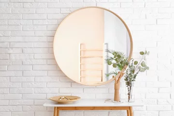 Fotobehang Boho Big round mirror, table with jewelry and decor near brick wall in hallway interior  © New Africa