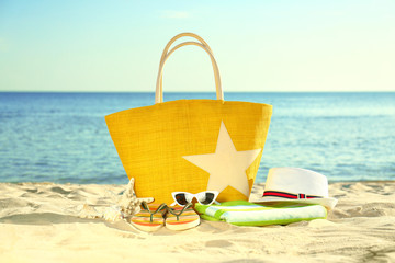 Fototapeta na wymiar Composition with stylish beach accessories on sand near sea