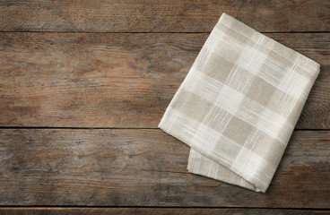 Folded kitchen towel on wooden table, top view. Space for text