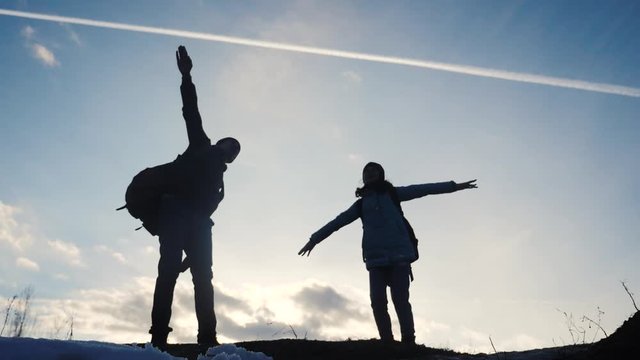happy family dad with daughter teamwork tourists silhouette concept. slow motion video. dad and daughter with backpacks show hand gesture plane journey airplane. man and young happiness girl a walking