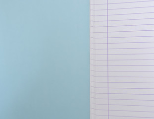 Open blank  notebook with lined papers on light blue background with copy space.